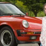 En person står bredvid en Porsche 911. (AI text)