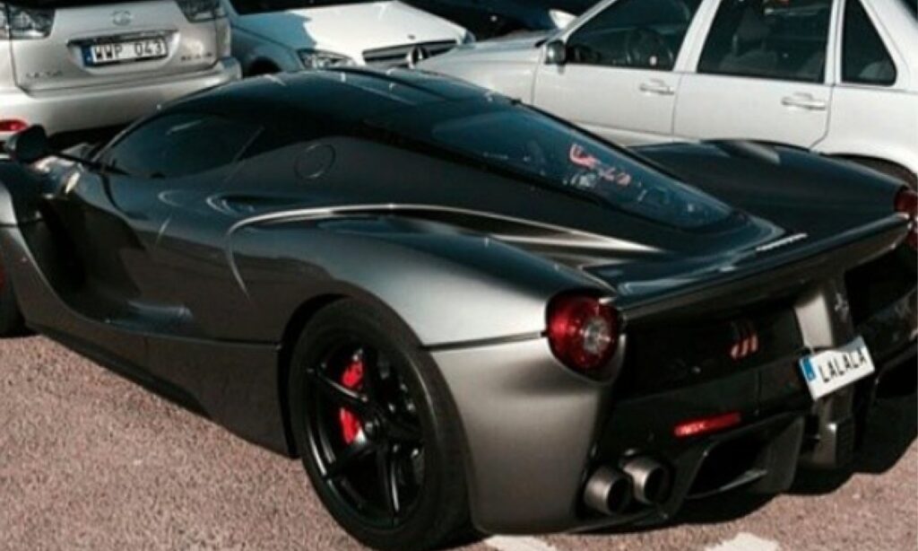 En svart och silver sportbil parkerad i en parkeringsplats (AI text)