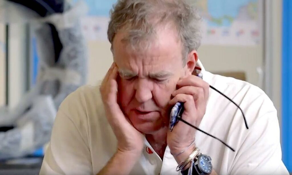 En man pratar i sin mobiltelefon medan han sitter i en bil. (AI text)