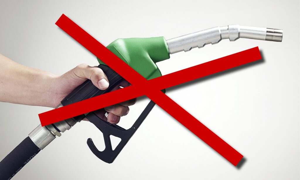 En person håller en gaspump med en skylt som visar "ingen gas". (AI text)