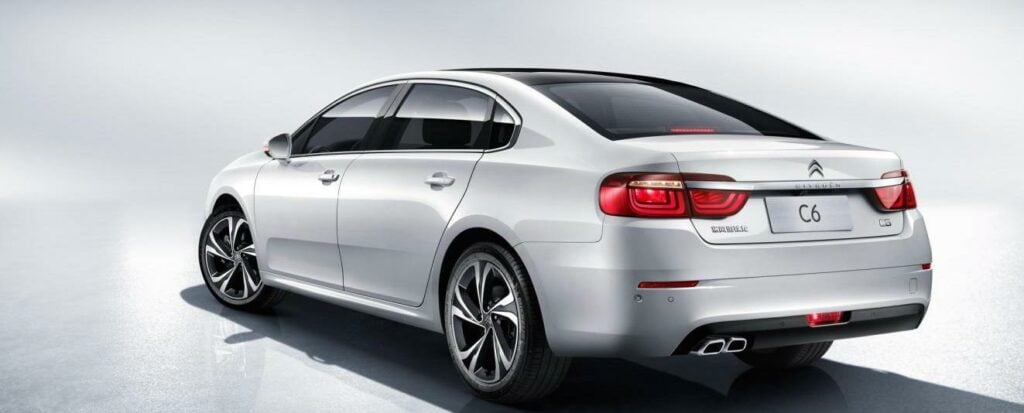 En vit bil i en studioscen. (AI text)