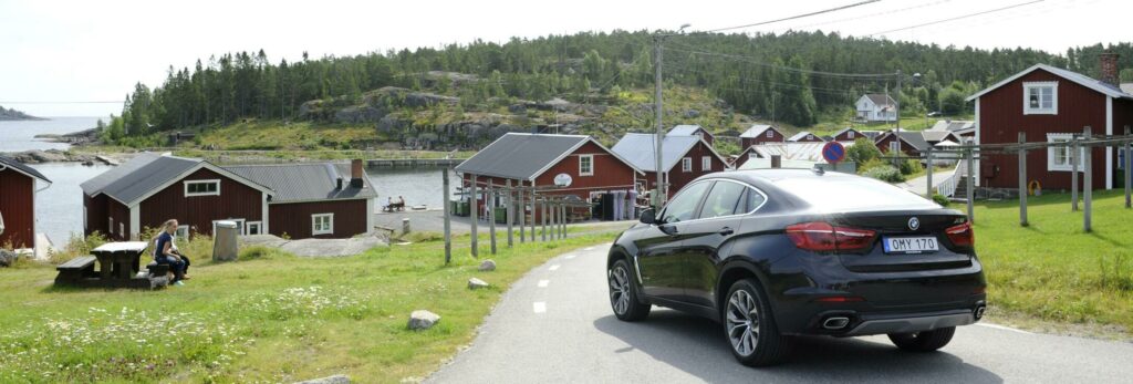 En bil kör genom en liten by. (AI text)