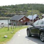 En bil kör genom en liten by. (AI text)