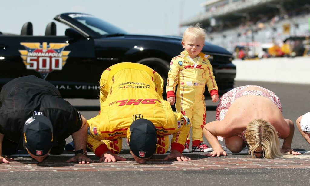 En gång i tiden var banan helt belagd med tegelstenar. I dag återstår en meter vid mållinjen, som segraren alltid kysser efter målgång. Här är det Ryan Hunter-Reay som firar sin seger 2014 tillsammans med fru Beccy och den lätt skeptiske sonen Ryden. FOTO: Chris Graythen/Getty Images