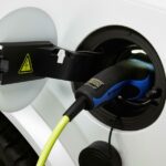 En vit bil är uppkopplad till en elladdare. (AI text)