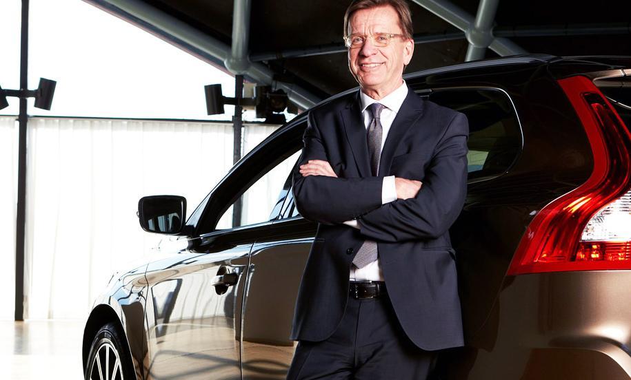 En man i kostym står bredvid en bil. (AI text)