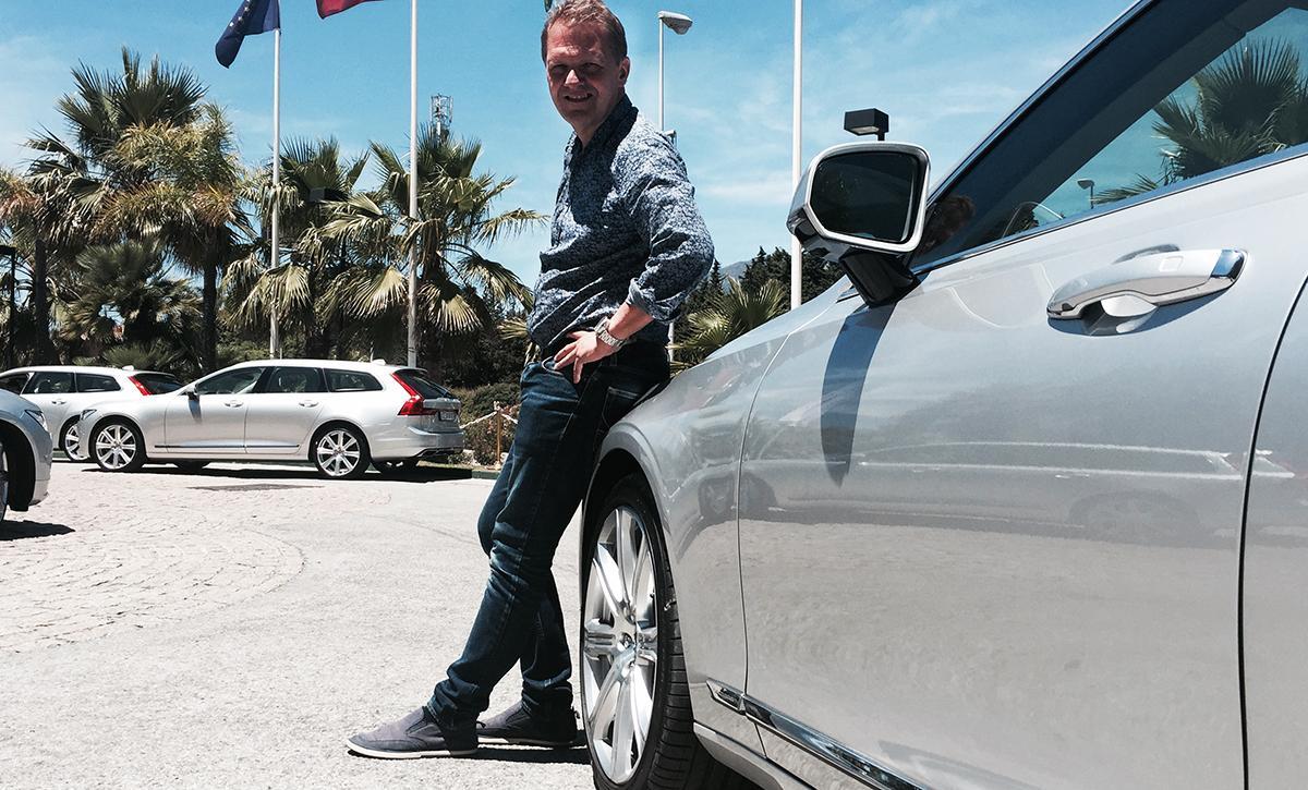 En man står bredvid en Mercedes-Benz S-class. (AI text)