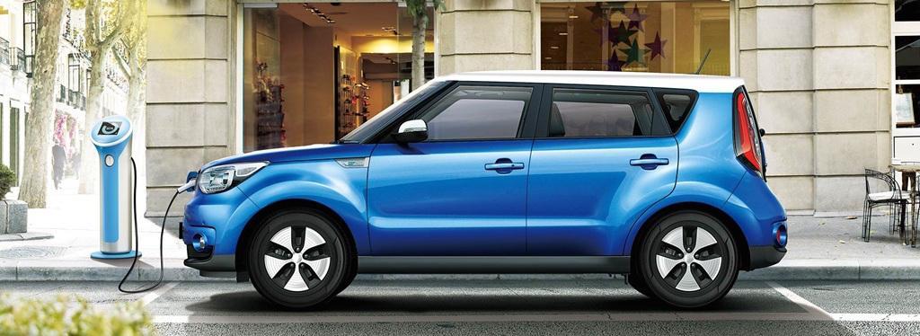 En blå Kia Soul parkerad framför ett byggnad. (AI text)