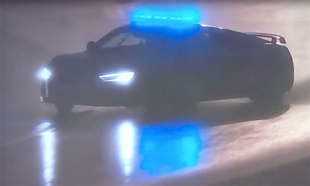 En polisbil kör nedför en väg i regnet. (AI text)