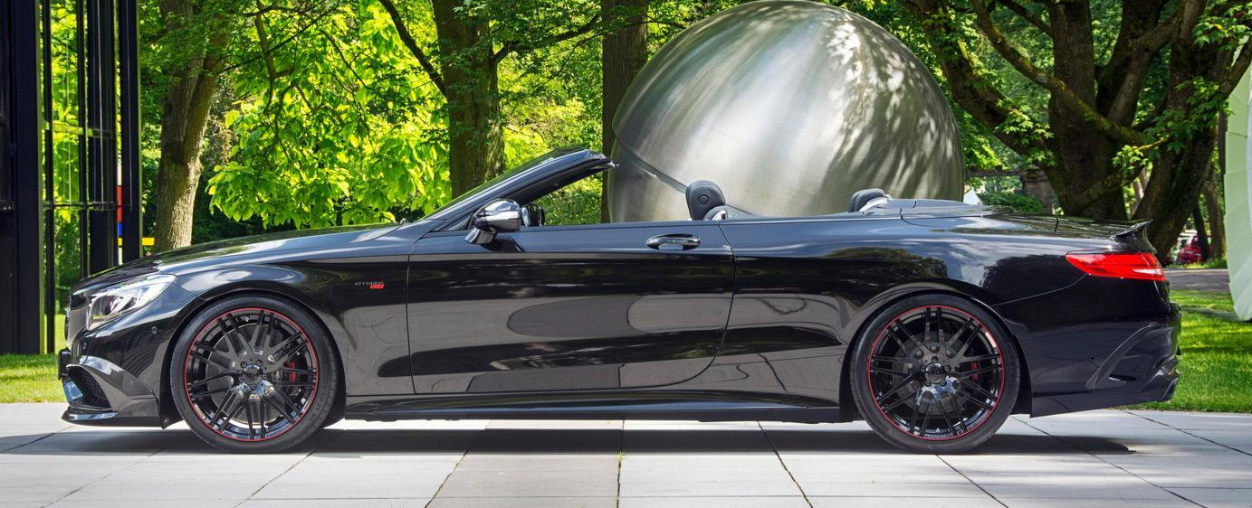 En Mercedes S-klass cabriolet parkerad framför en stor skulptur. (AI text)