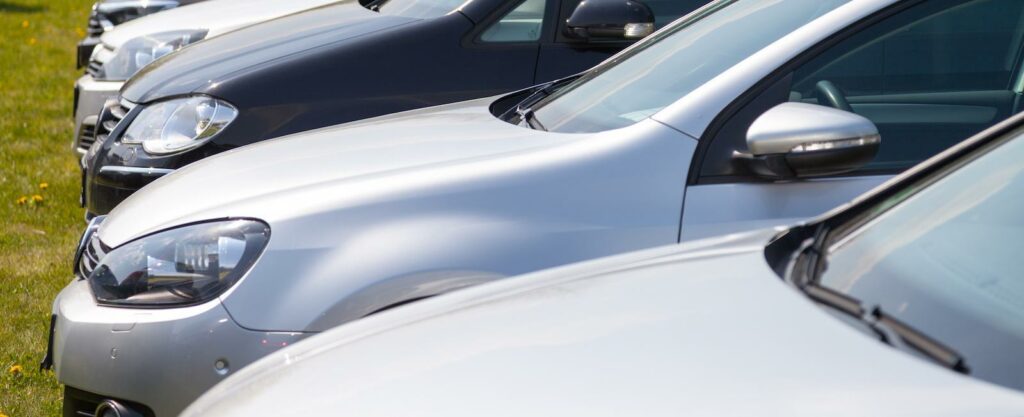 En rad bilar parkerade i en parkeringsplats. (AI text)