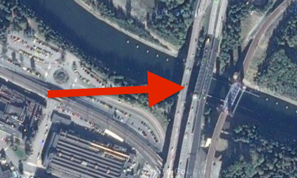 En bil är parkerad på en bro över en flod. (AI text)