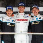 En grupp personer står på en podiet med pokaler. (AI text)