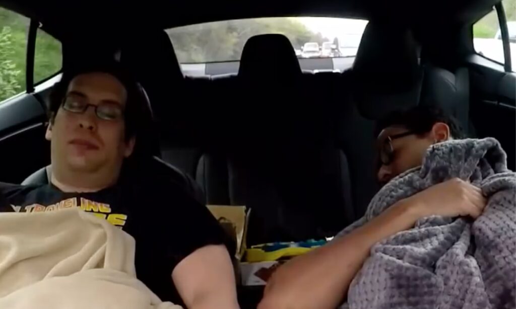 Två personer sover i baksätet av en bil. (AI text)