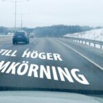 En bil kör ned en väg med en skylt som säger 'all til hoger er om' (AI text)