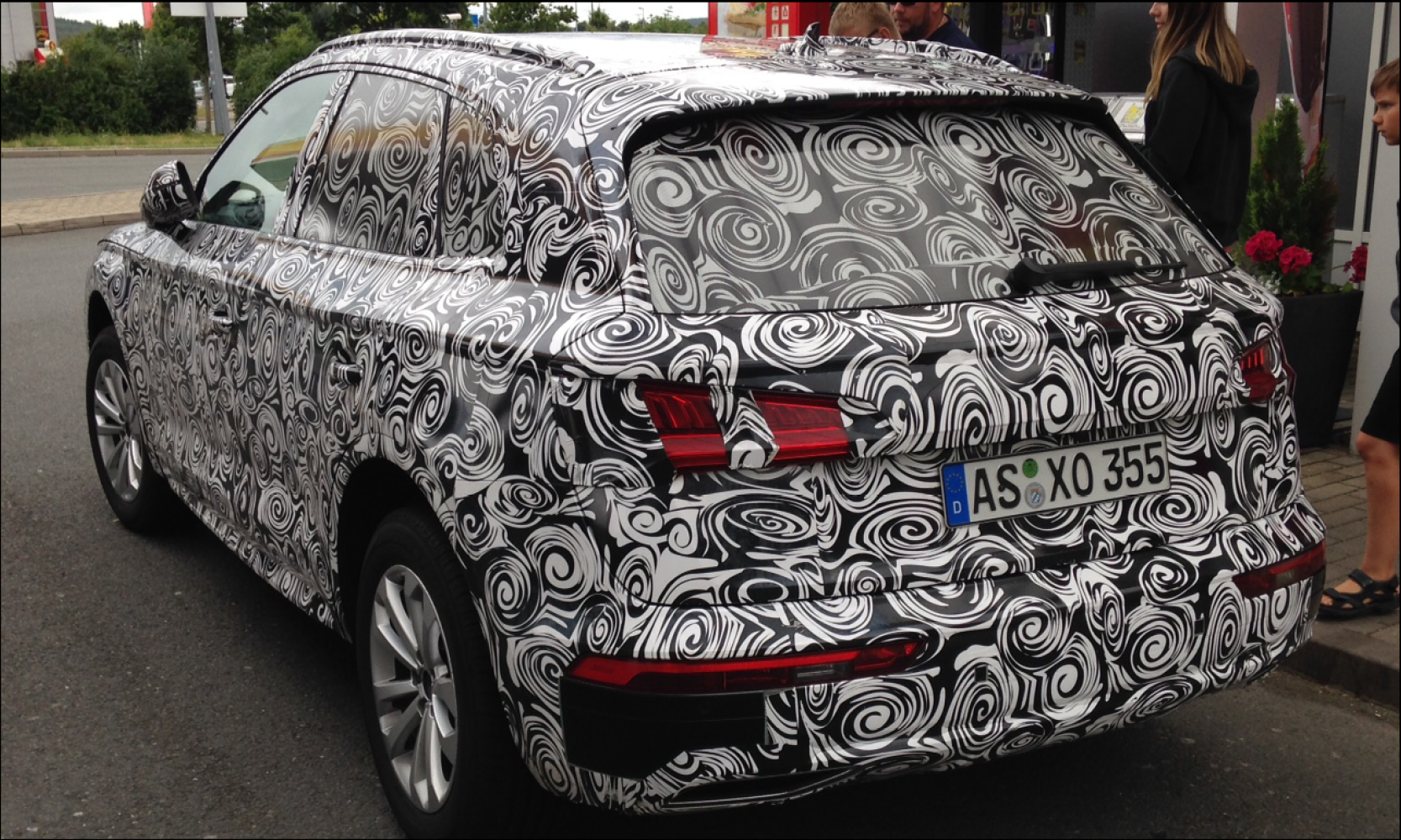 En bil med kamouflaggmönster på bakdelen. (AI text)