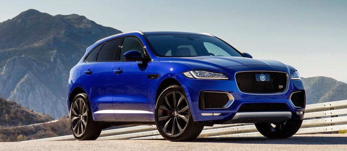 En blå jaguar SUV kör nedför en bergsväg. (AI text)