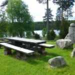 En picknickbord i en gräsmatta (AI text)