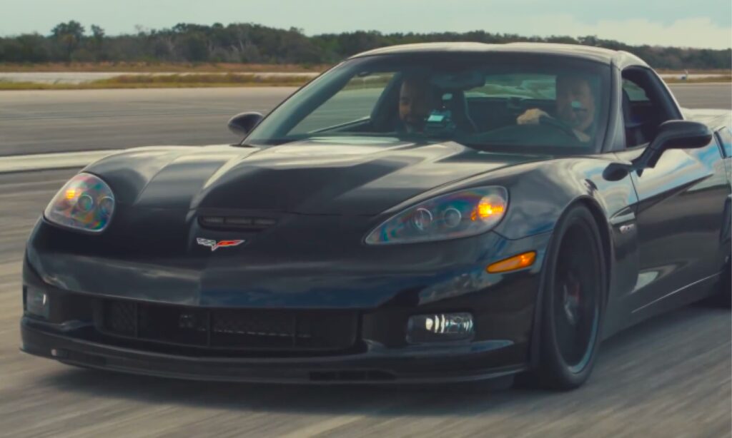 En svart Chevrolet Corvette Z06 kör längs en start- och landningsbana. (AI text)
