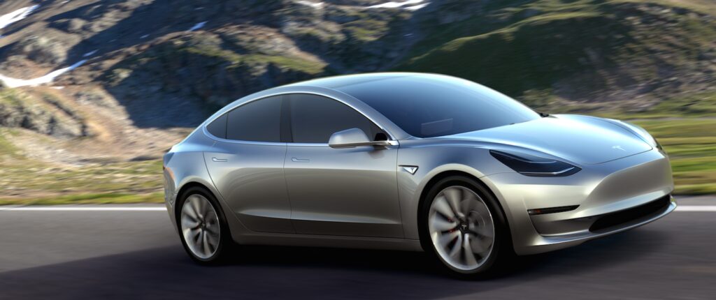 En Tesla Model 3 kör längs en bergig väg. (AI text)