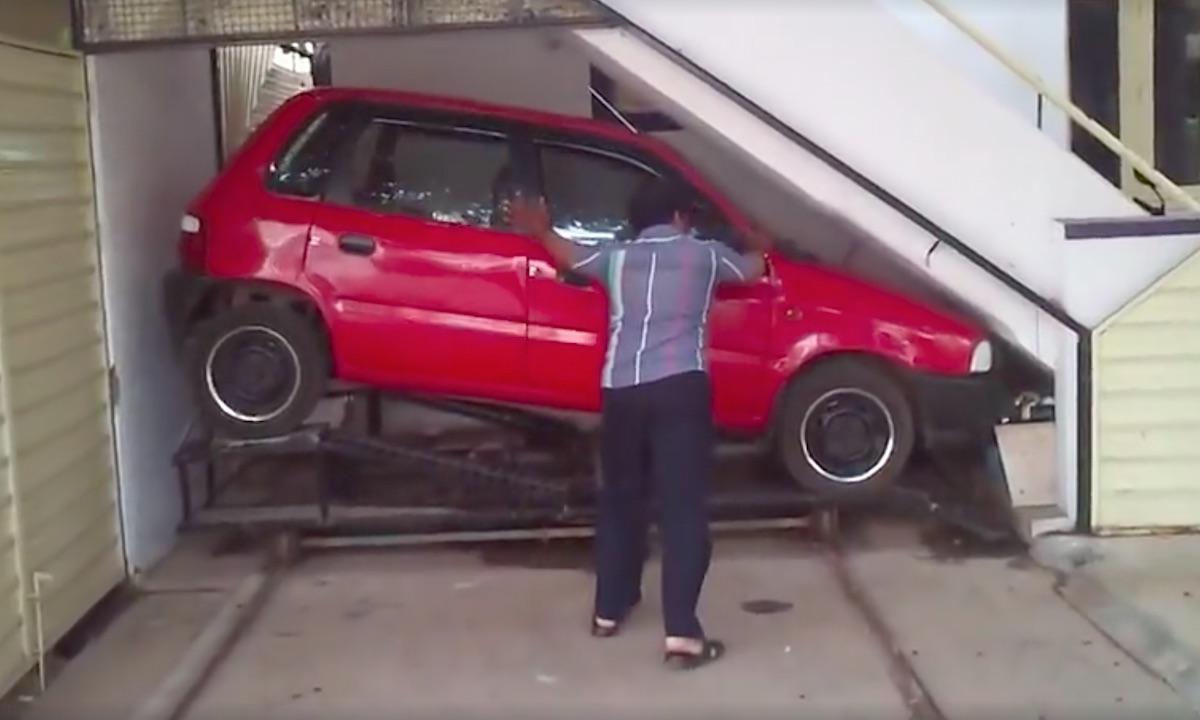 En man tar bort en bil från ett garageläktare. (AI text)