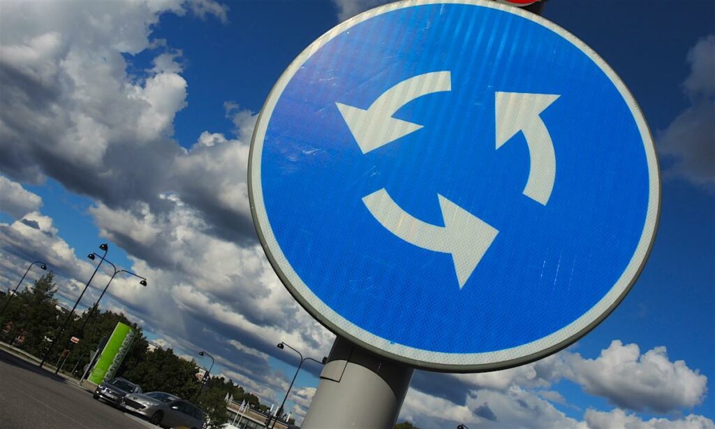 En trafikskylt med pilar som pekar i olika riktningar. (AI text)