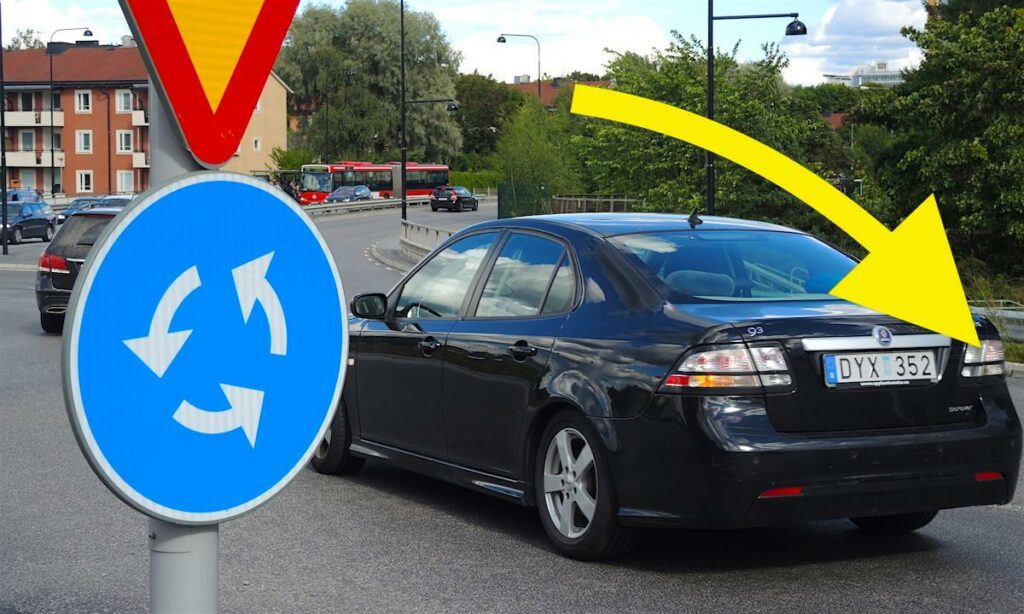 En bil står parkerad på en gata med en skylt som säger'sväng vänster'. (AI text)