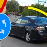 En bil står parkerad på en gata med en skylt som säger'sväng vänster'. (AI text)