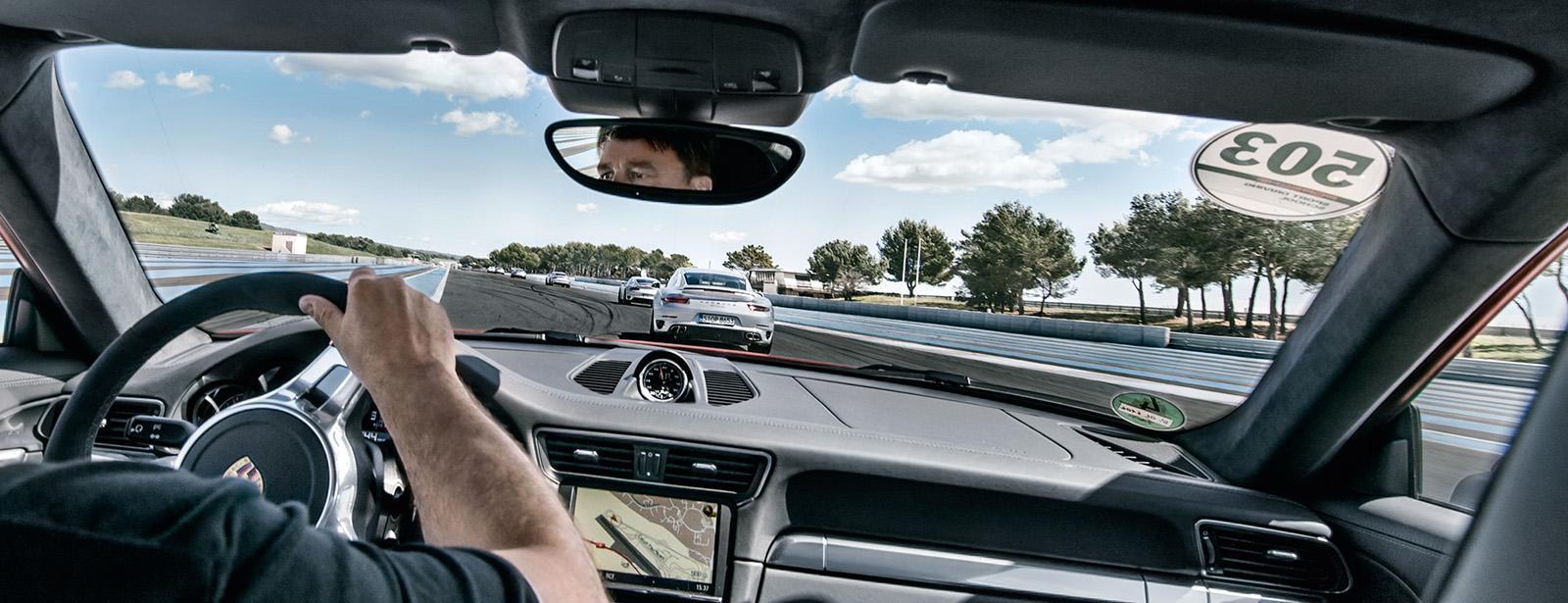 En man kör en bil på en racerbana. (AI text)