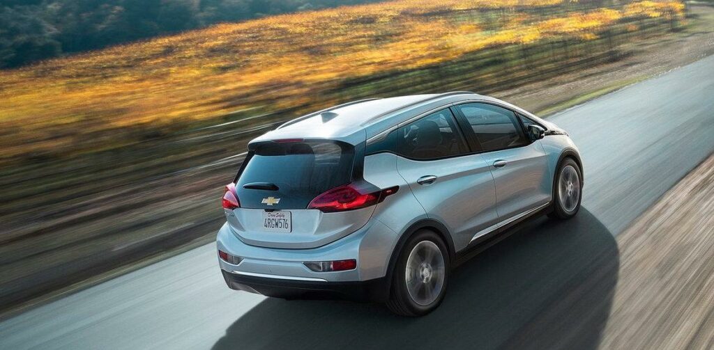 Chevrolet Bolt EV kör längs en landsväg. (AI text)