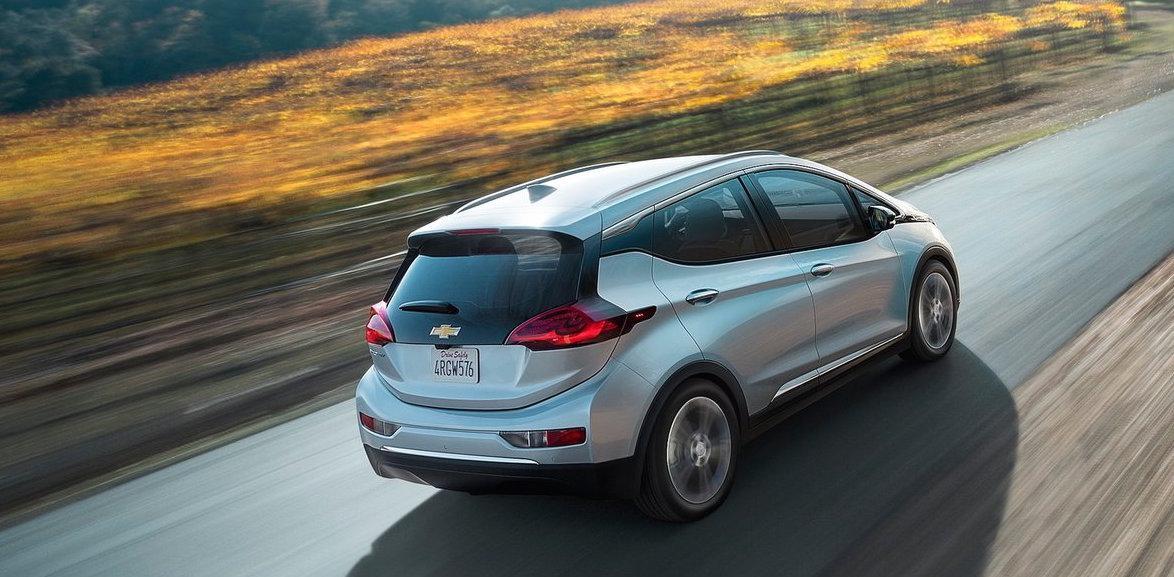 Chevrolet Bolt EV kör längs en landsväg. (AI text)
