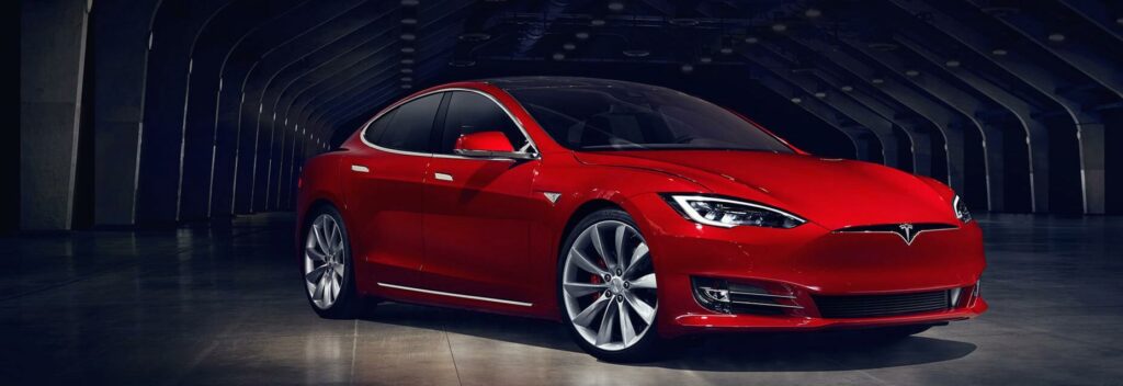 En Tesla Model S i en mörk tunnel. (AI text)