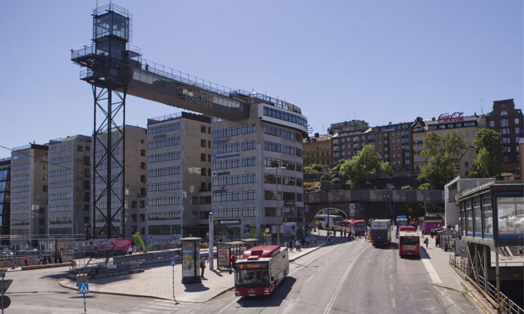 En stadsgata med en bro och en bil. (AI text)