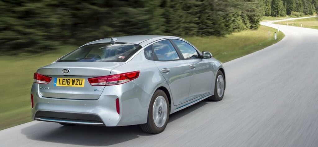 En silverfärgad bil kör nerför en landsväg. (AI text)