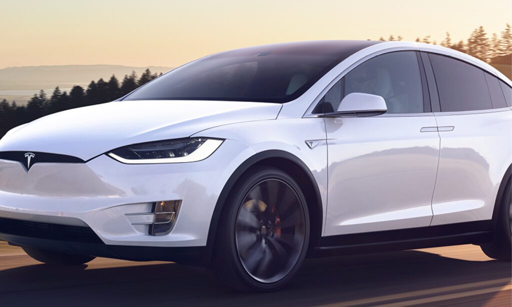 Tesla Model X kör på en landsväg. (AI text)