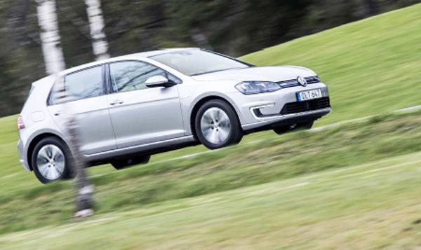En Volkswagen Golf e-GTI kör nerför en backe. (AI text)