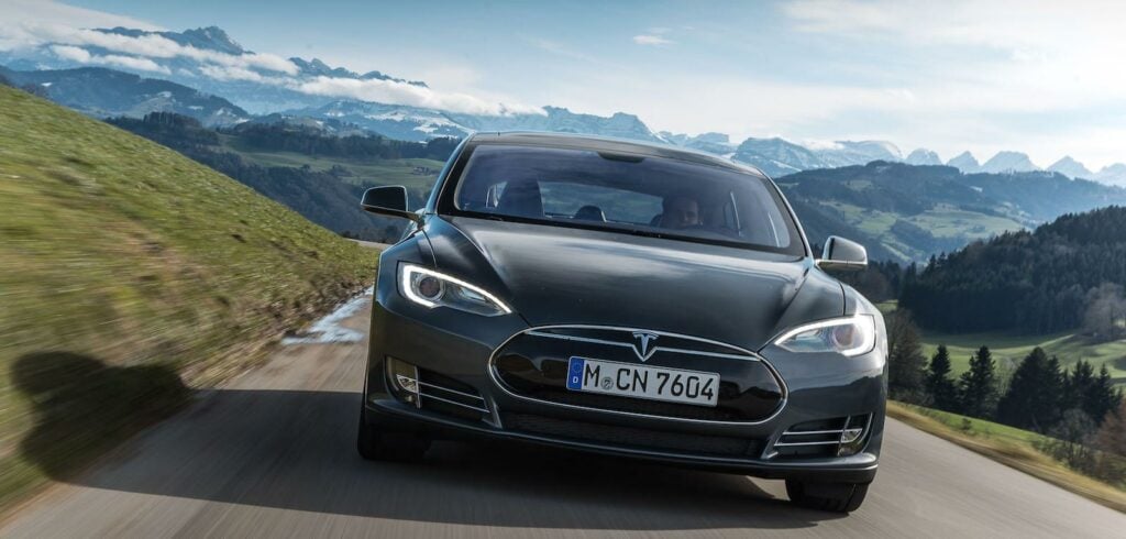 Tesla Model S kör nerför en bergsväg. (AI text)