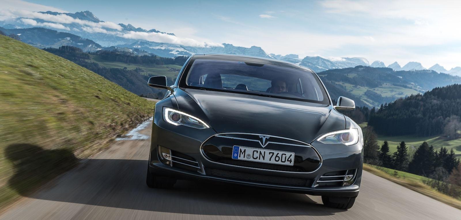 Tesla Model S kör nerför en bergsväg. (AI text)