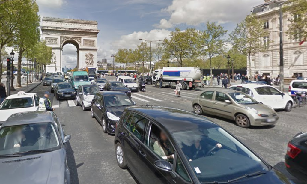 En gata med bilar och folk. (AI text)