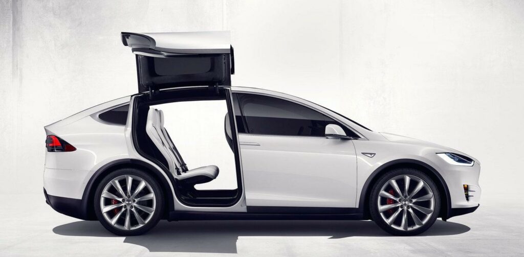 Tesla Model X med öppna dörrar i ett vitt studioscenarie (AI text)