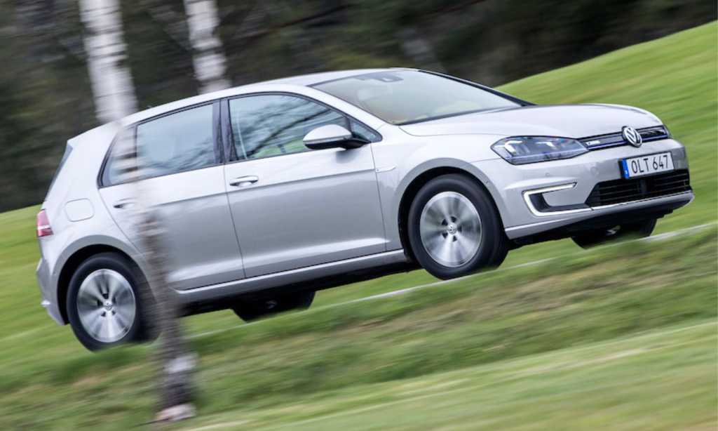 En Volkswagen Golf E - EV kör nerför en backe. (AI text)