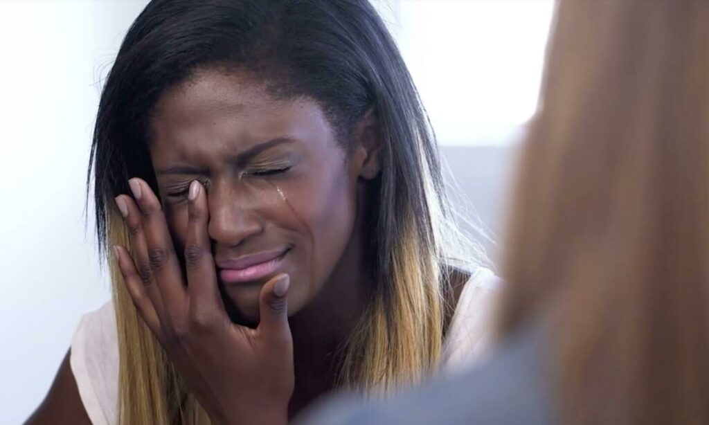 En kvinna gråter under ett möte med en läkare. (AI text)