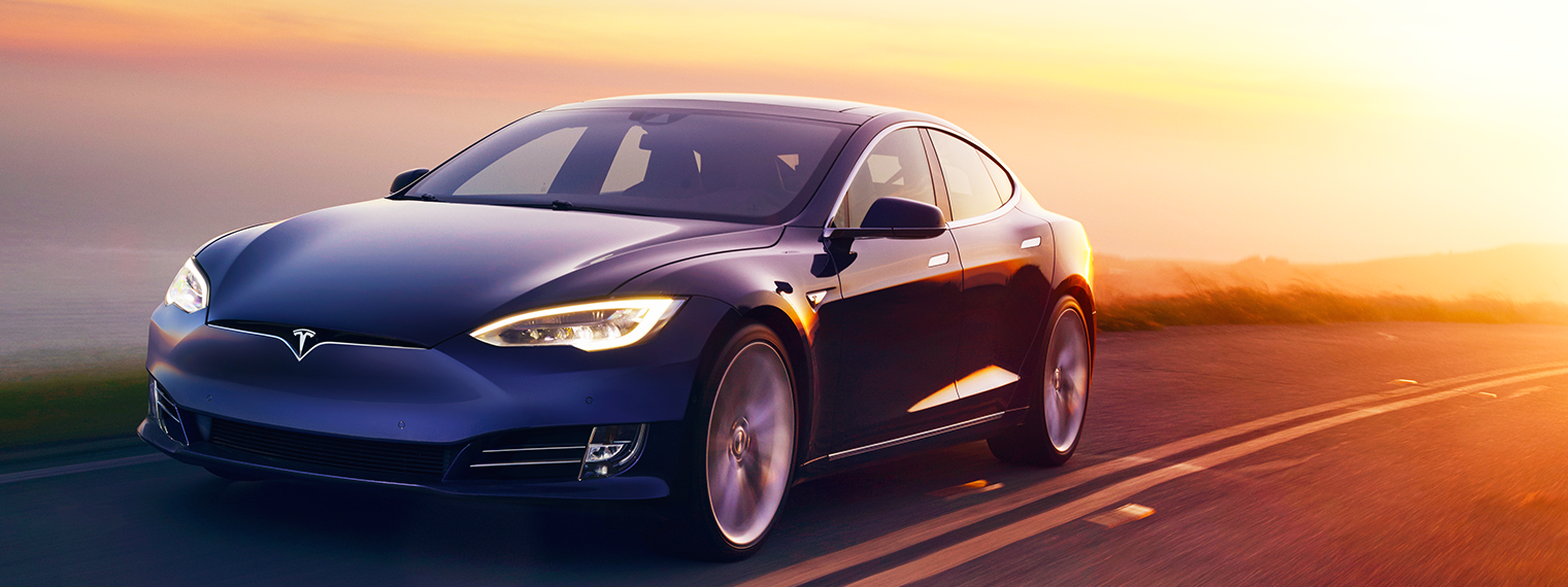 En Tesla Model S kör nerför en väg vid solnedgången. (AI text)