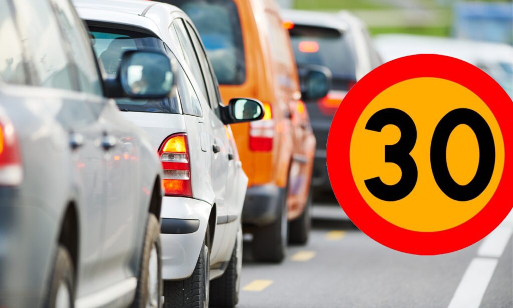 En bil står parkerad på en gata med en 30 mph-skylt. (AI text)