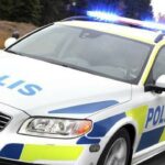 En polisbil kör på vägen. (AI text)