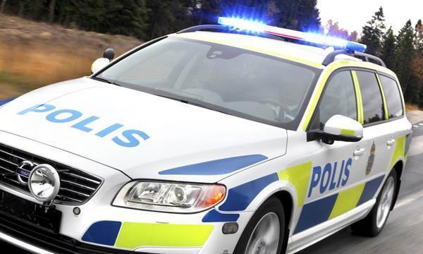 En polisbil kör på vägen. (AI text)