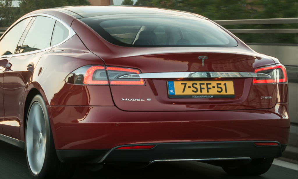 En Tesla Model S kör på motorvägen. (AI text)