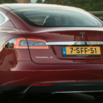 En Tesla Model S kör på motorvägen. (AI text)