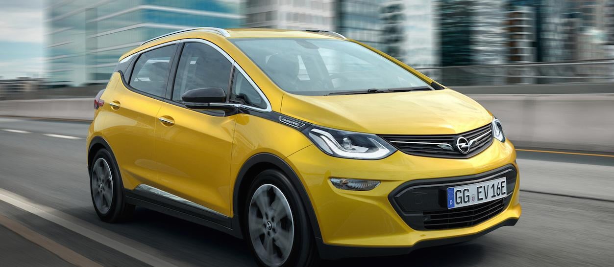 En gul Opel bil kör nerför en stadsgata. (AI text)