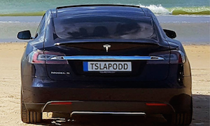 En Tesla Model X parkerad på en strand. (AI text)